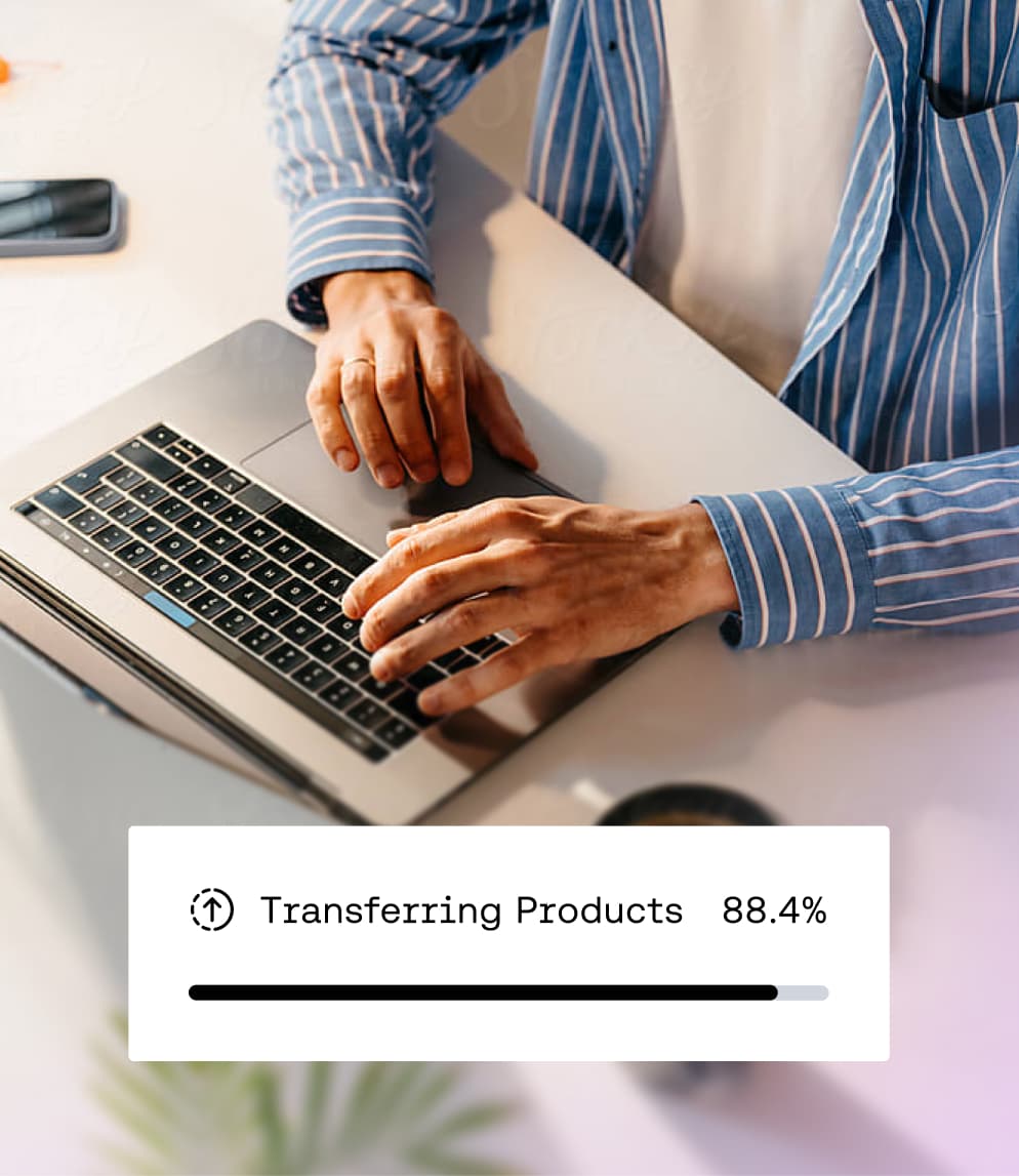 Person, die an einem Laptop tippt, mit einer Einblendung, die den Fortschritt der Datenmigration bei der Übertragung von Produkten bei 88,4 % anzeigt.